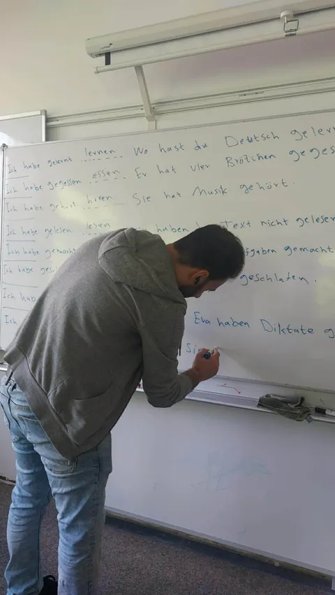 Student practising German writing on the whiteboard